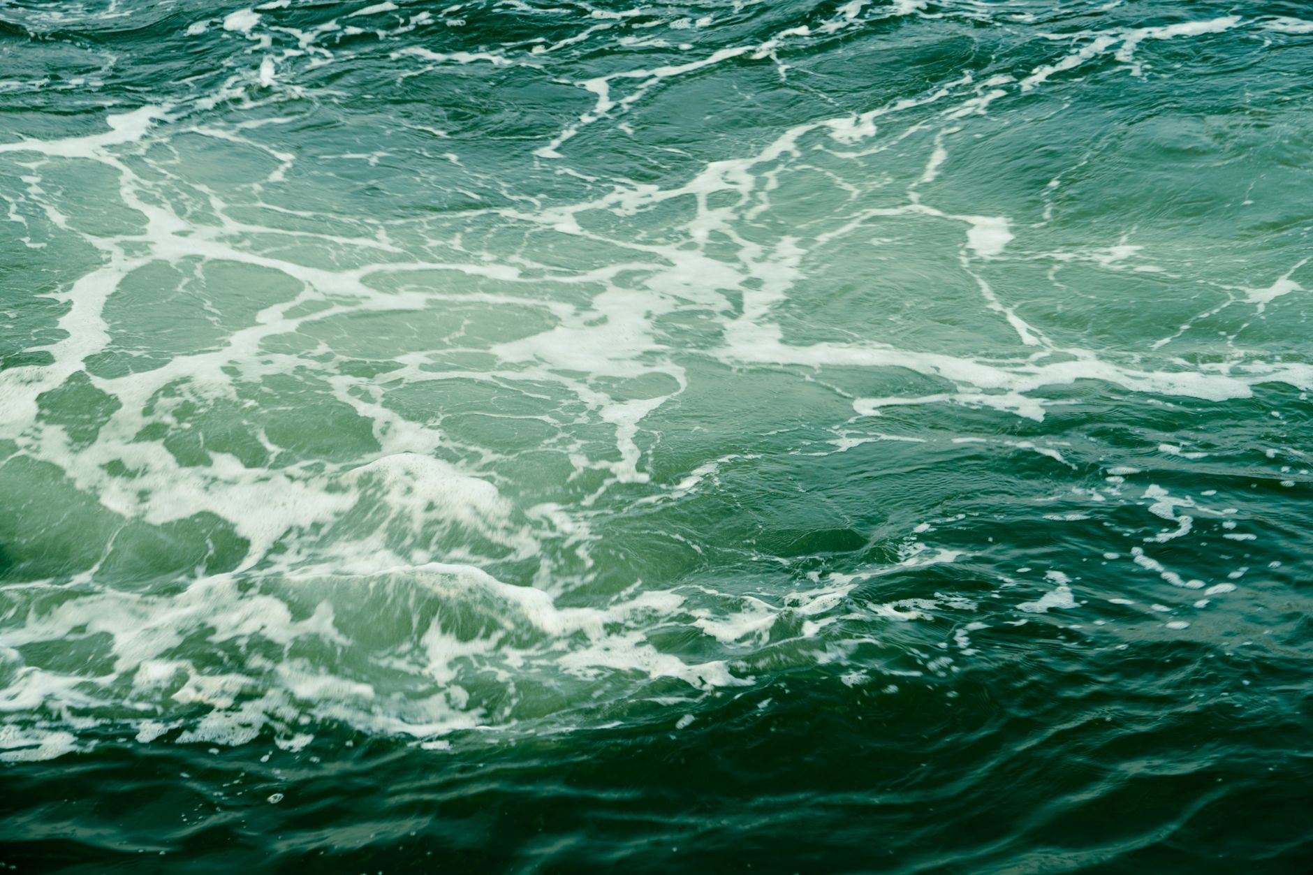 Sunlight glittering on turquoise ocean waves seen from above